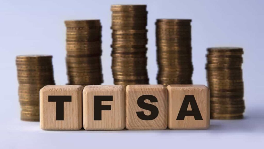 TFSA (Tax free savings account) acronym on wooden cubes on the background of stacks of coins