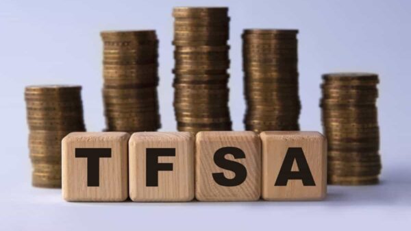 TFSA (Tax free savings account) acronym on wooden cubes on the background of stacks of coins