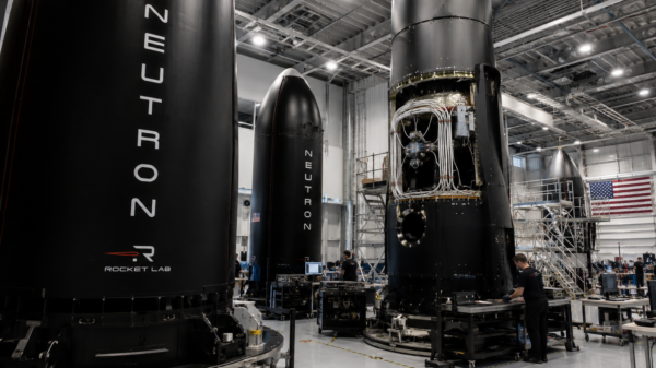 Rocket Lab engineers work around Neutron rocket hardware inside a large assembly facility.