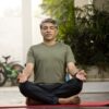 Man meditating in lotus position outdoor on patio