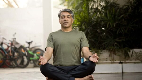 Man meditating in lotus position outdoor on patio